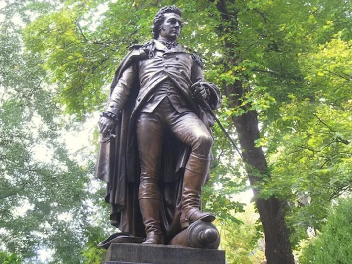 looking up at bronze statue of John Glover in a tree filled park