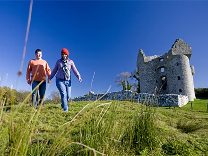 People walking next to a castle