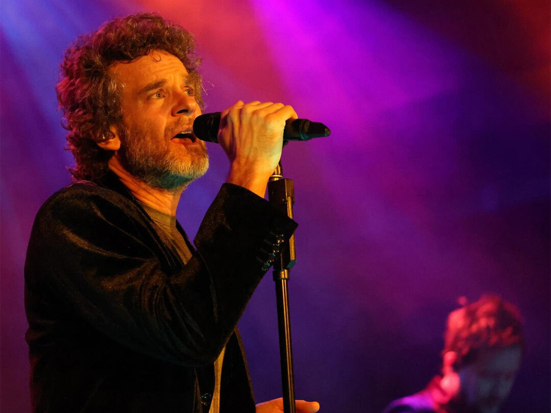 Carbon Leaf lead singer belting into a microphone, red and purple lighting