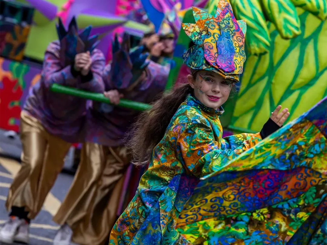 Little girl in vibrant colored outfit marching in parade