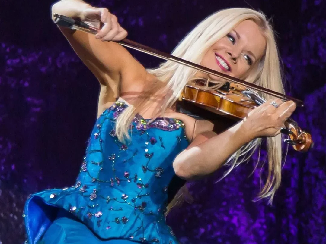 Fiddler Mairead Nebitt in a satin ball gown happily playing her instrument