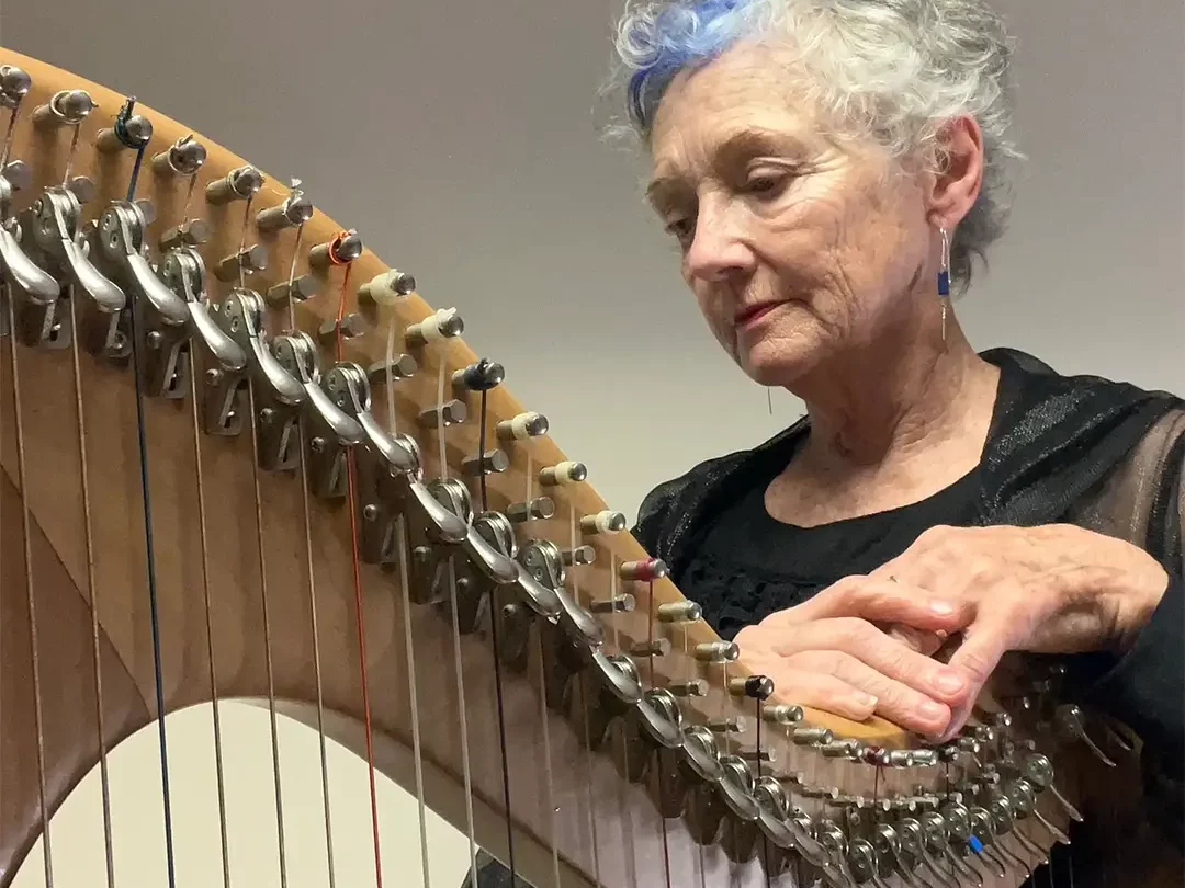 Regina Delaney elegantly leaning on her harp