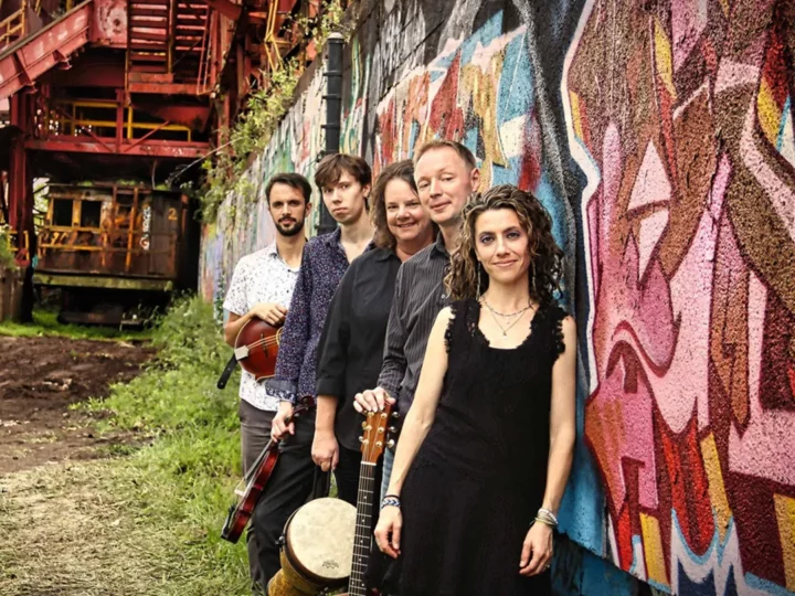 Members of the band Runa leaning against a graffiti wall