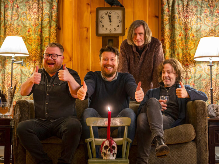 Cantrip bandmembers grouped in a vintage setting around a candle
