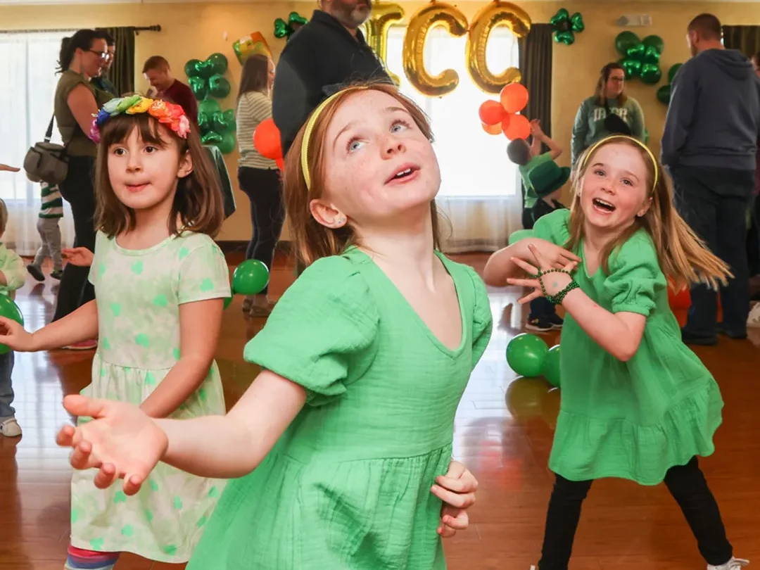 Girls dressed in green dancing on Family Day