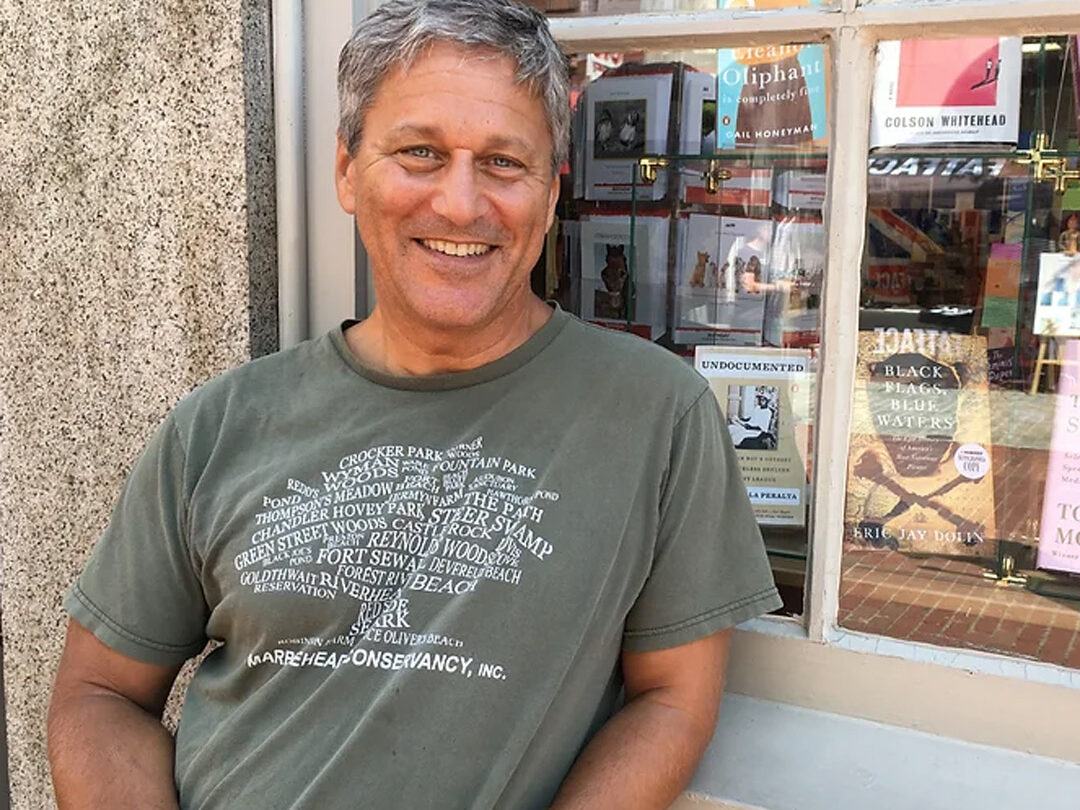 Eric J Dolan leaning against storefront