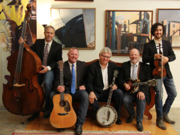 Rock Hearts Band sitting on a couch with their instruments in an art gallery