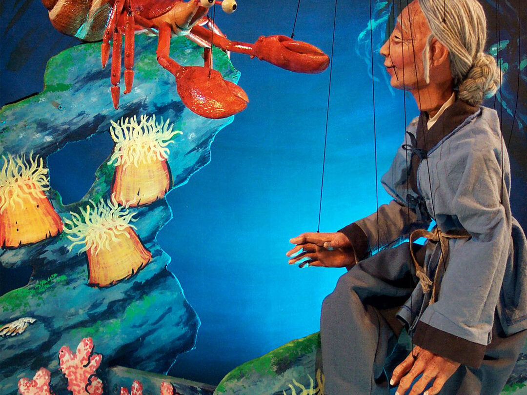 Image of a marionette woman interacting with a lobster